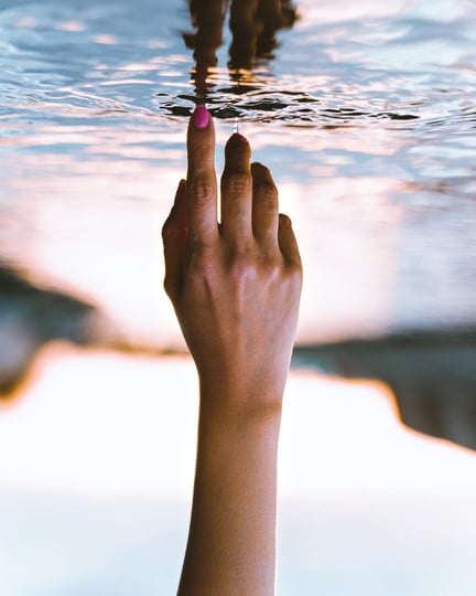 Woman's Finger Touching Water Surface